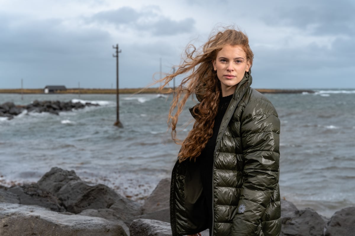 woman-standing-seashore-darkgreen-puffer-jacket.jpeg
