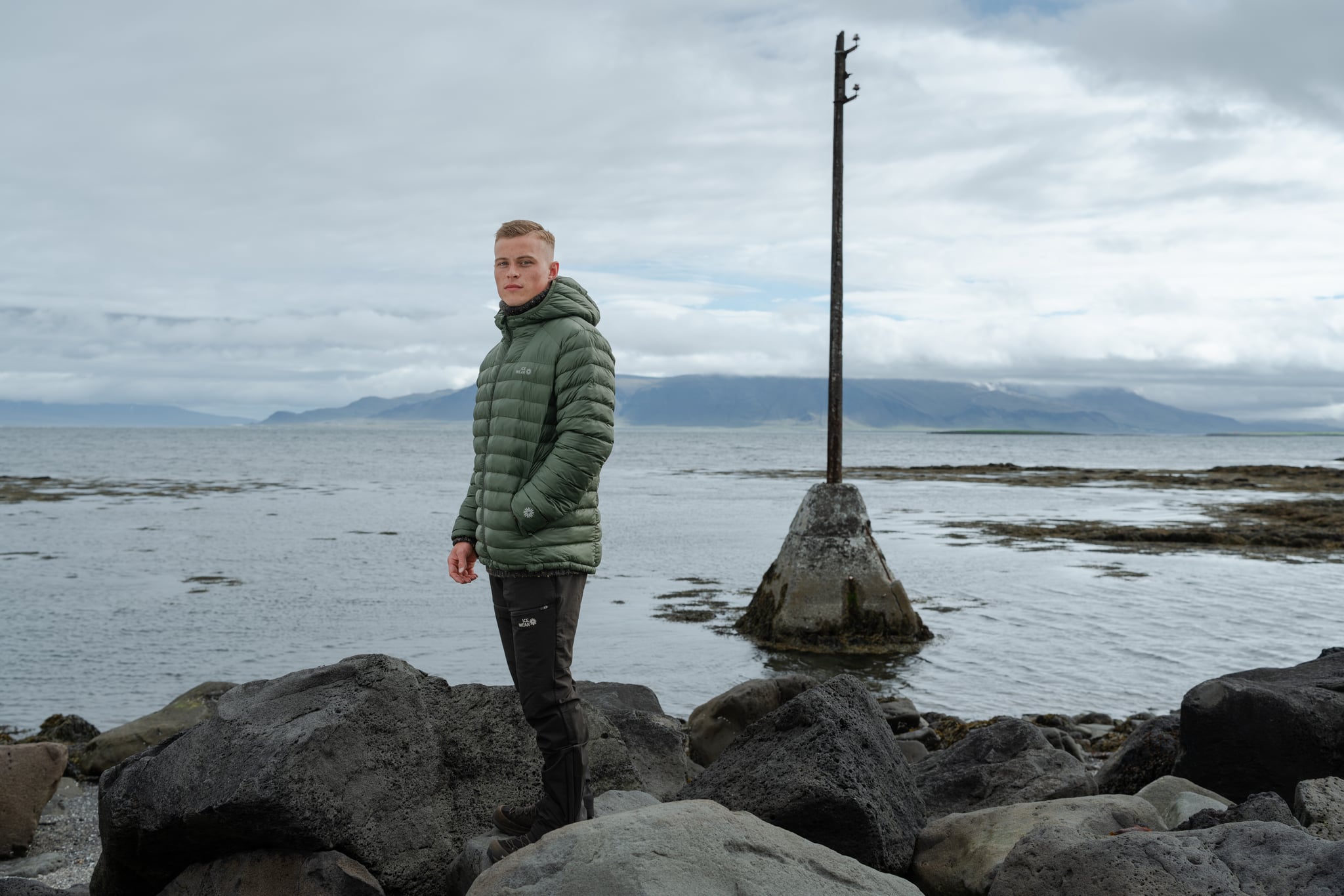 man-green-downjacket-beach.jpeg