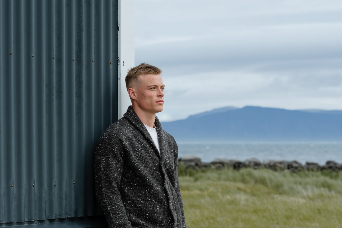 man standing next to a old house