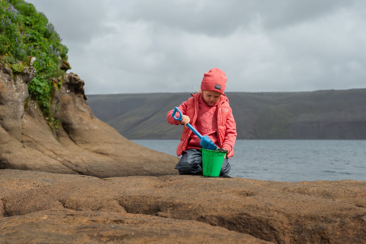 Boy shovelling in a bucket.