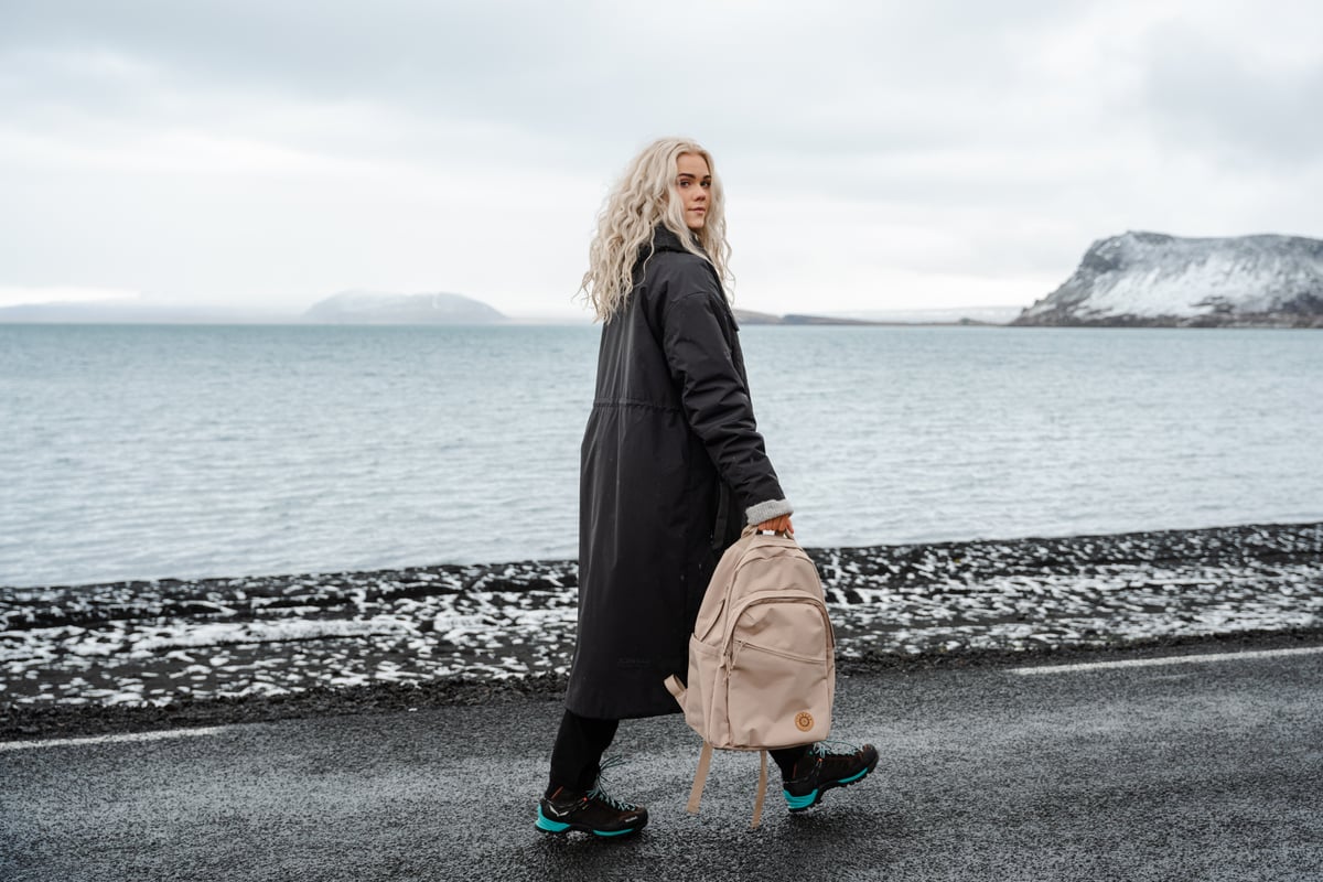 woman with backpack walking on the road