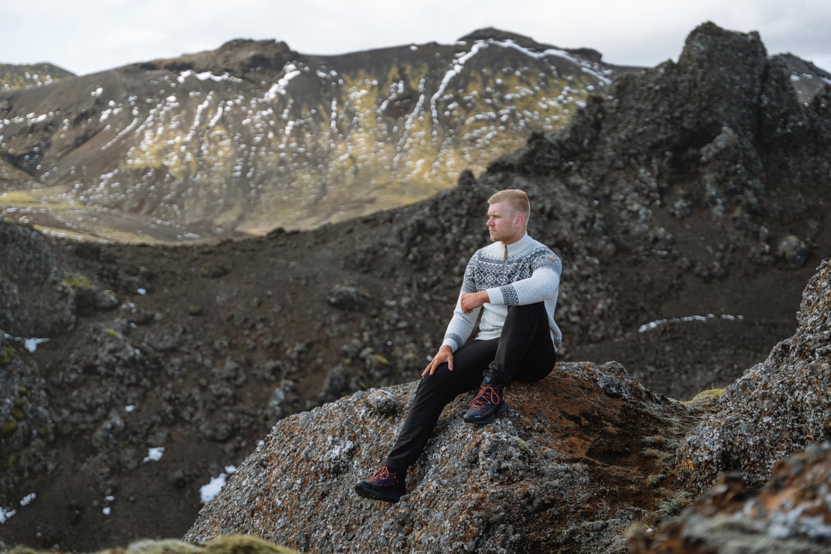 man sitting on a cliff in the mountain