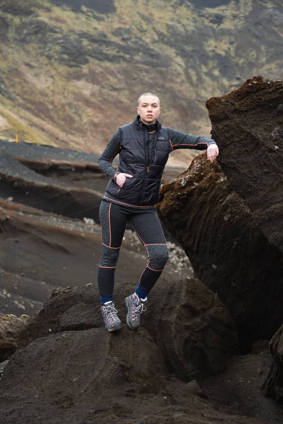 woman leaning on Icelandic black rock