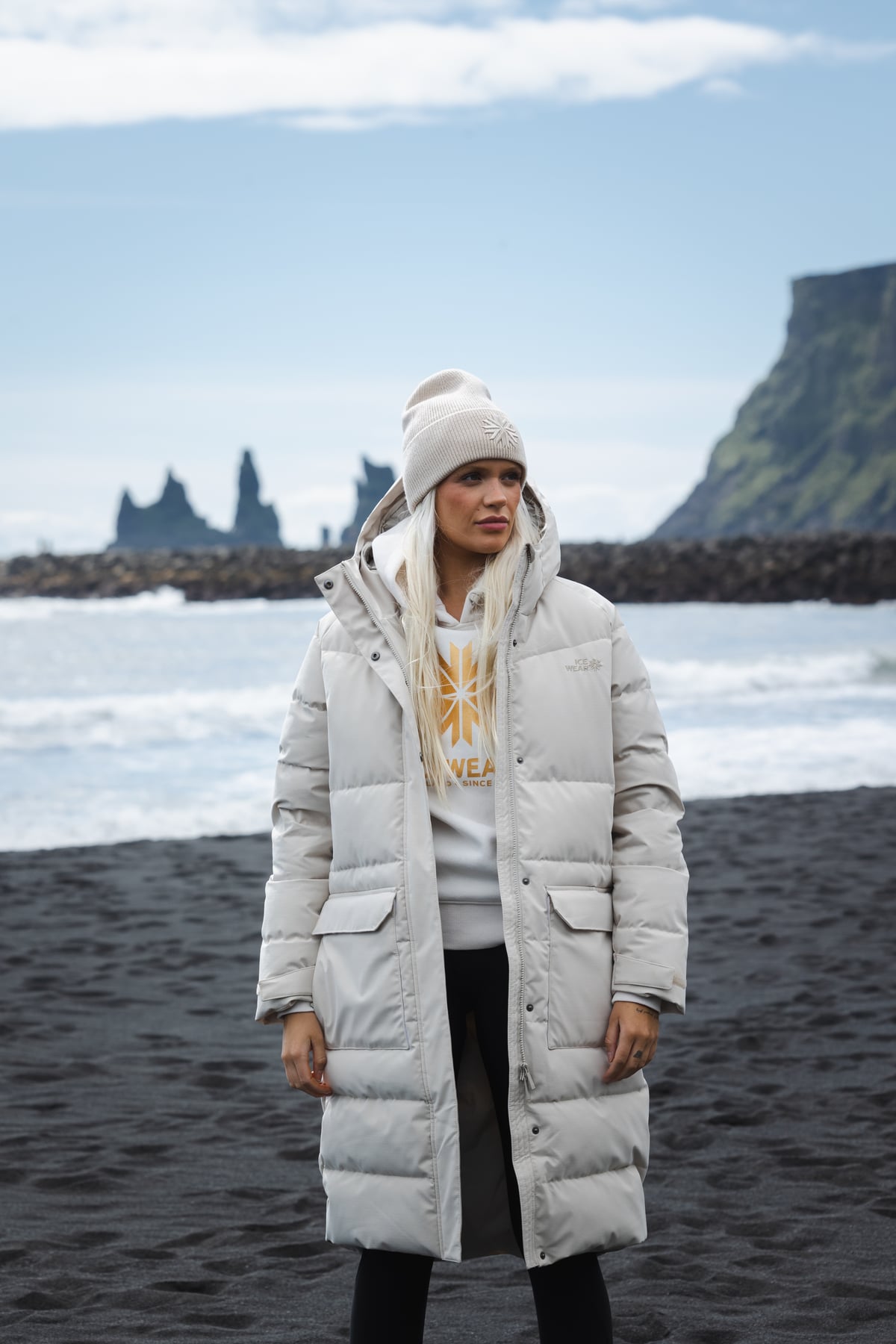 woman-white-long-hat-jacket-blackbeach.jpeg