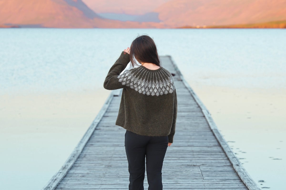 girl on a long pier, looking out to sea