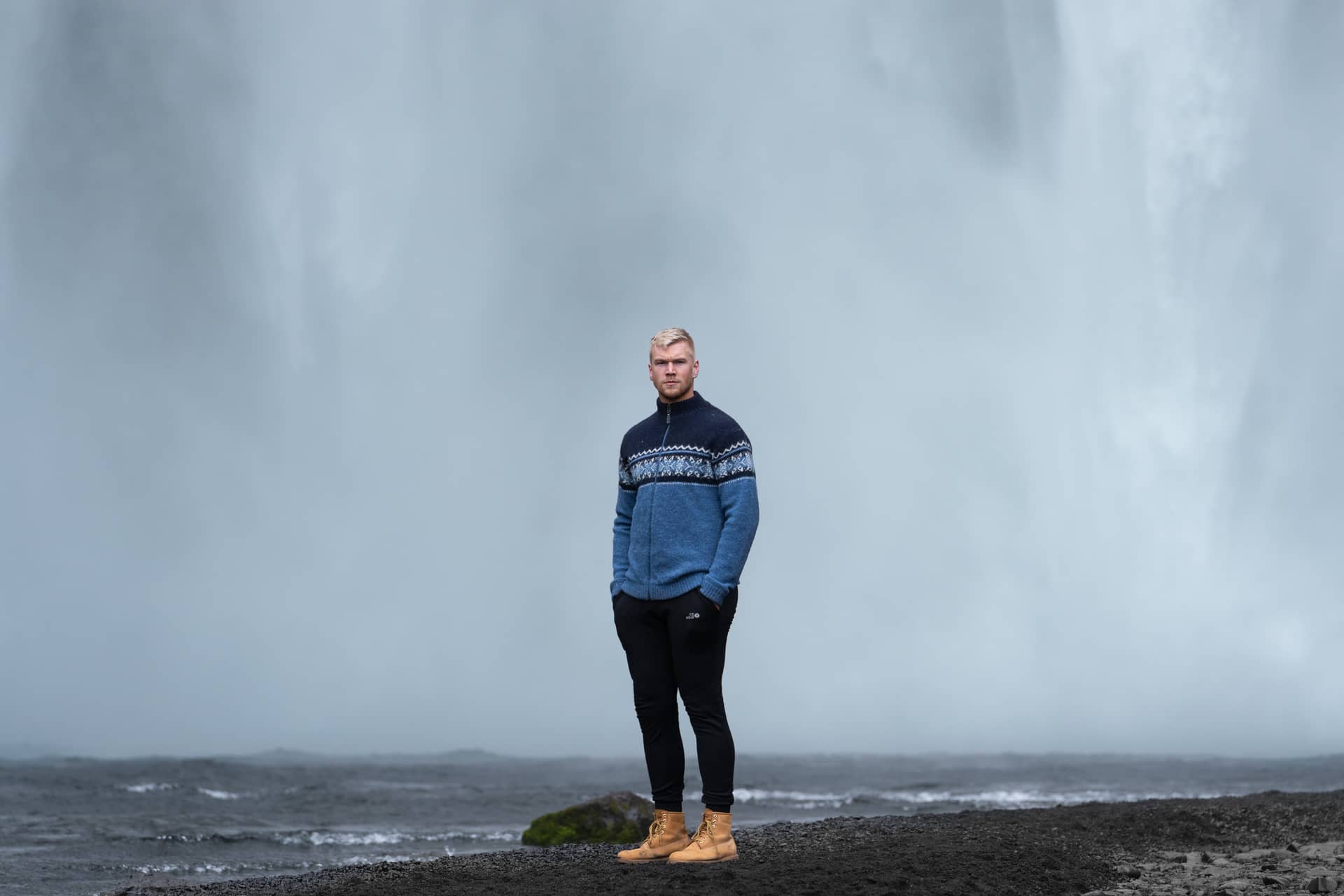 man standing by a Icelandic waterfall