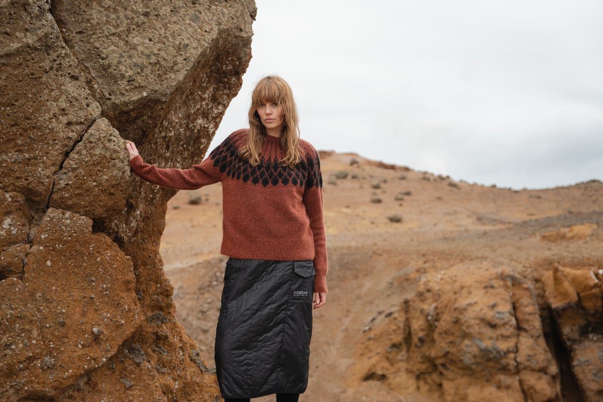 woman standing up by a big rock