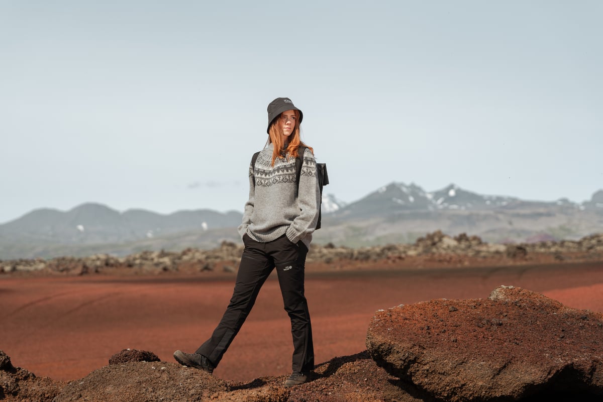 Eine Frau, die in roter Lava im Westen Islands spazieren geht