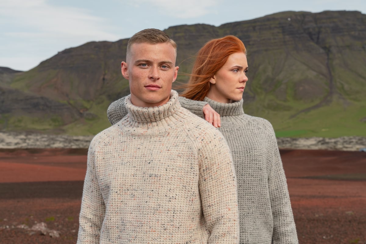 couple standing in red sand in Vest Iceland